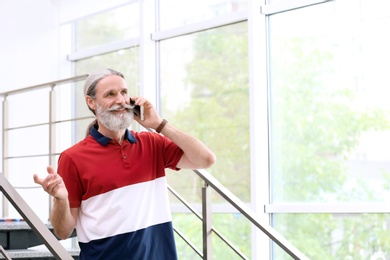 Photo of Handsome mature man with mobile phone, indoors