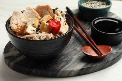 Photo of Delicious ramen served on white table, closeup. Noodle soup