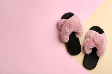 Pair of soft slippers on color background, flat lay. Space for text