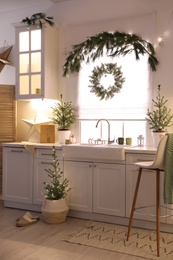 Small Christmas trees and festive decor in kitchen