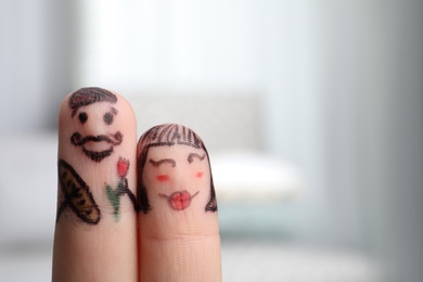 Two fingers with drawings of happy faces on blurred background, space for text. Spending time together