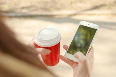 Photo of Young woman using phone outdoors on sunny day