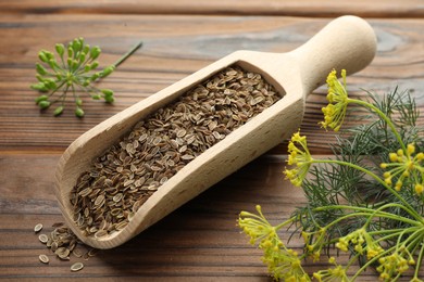 Photo of Scoop of dry seeds and fresh dill on wooden table, closeup