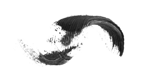 Photo of Smear of black mascara for eyelashes on white background