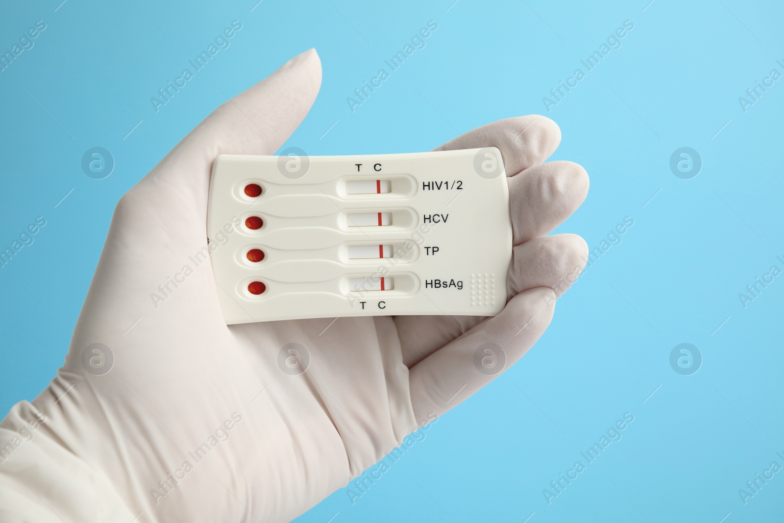 Photo of Doctor holding disposable express test for hepatitis on light blue background, closeup