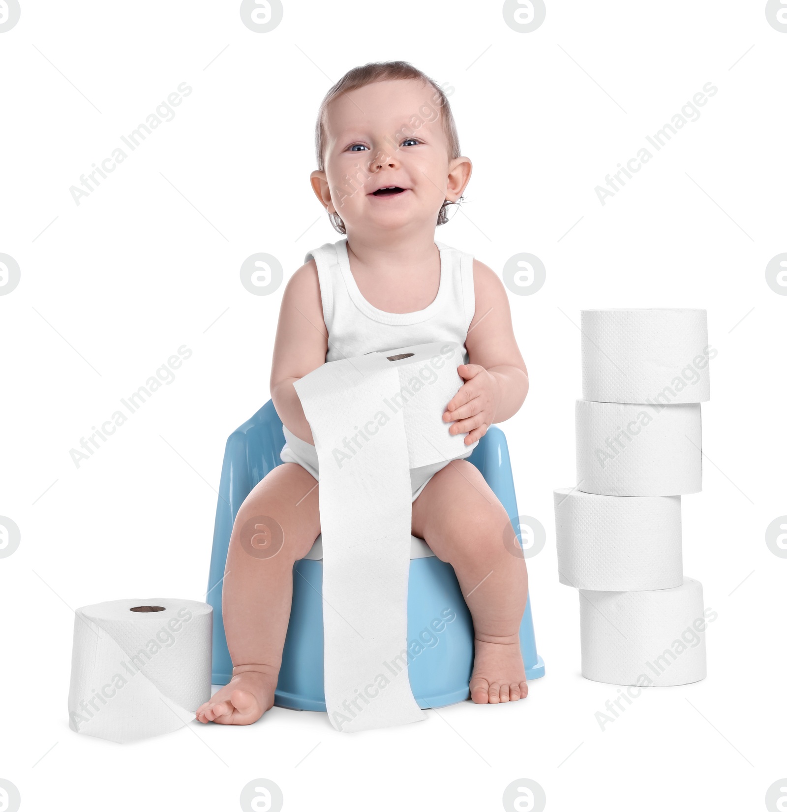 Photo of Little child sitting on baby potty and stack of toilet paper rolls against white background