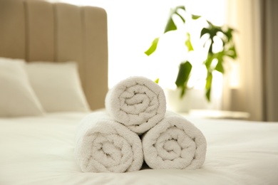 Clean white towels on bed at home