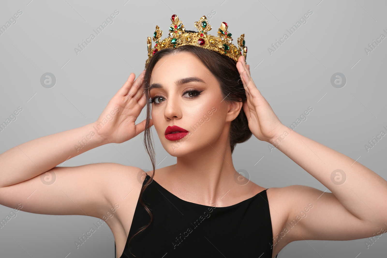 Photo of Beautiful young woman wearing luxurious crown on light grey background