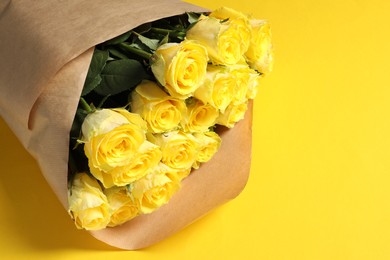 Beautiful bouquet of roses on yellow background, above view. Space for text