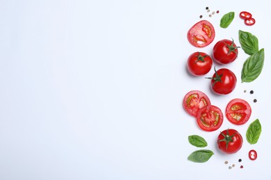 Composition with fresh basil leaves and tomatoes on white background, flat lay. Space for text