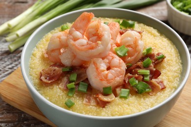 Fresh tasty shrimps, bacon, grits and green onion in bowl on table, closeup