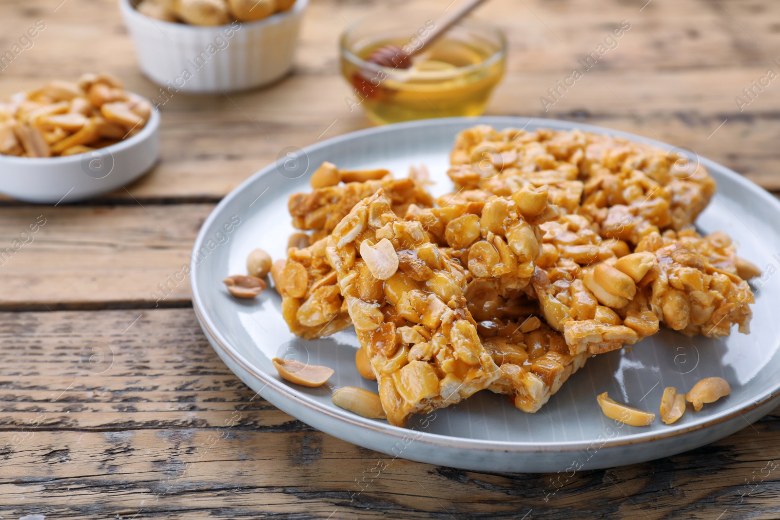 Photo of Delicious peanut kozinaki bars on wooden table