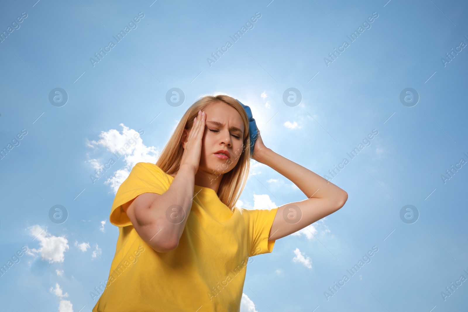 Photo of Woman with cold pack suffering from heat stroke outdoors