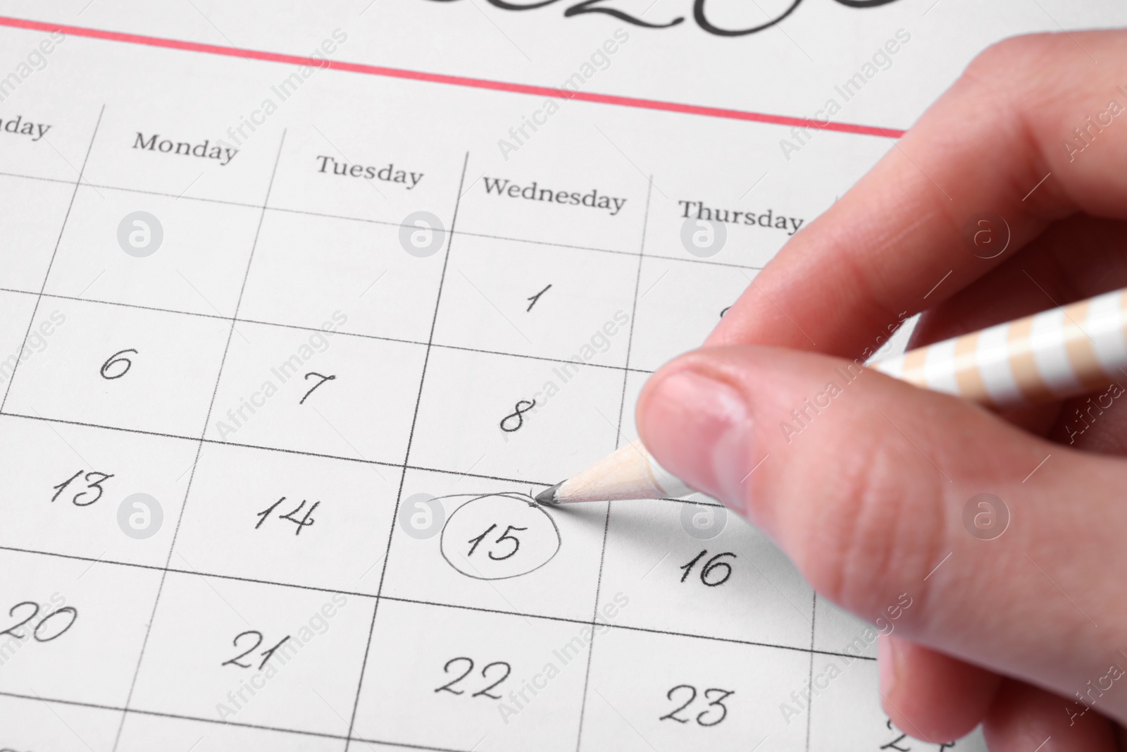 Photo of Woman marking date in calendar with pencil, closeup