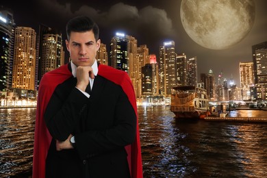 Image of Man wearing superhero costume and beautiful cityscape in night on background