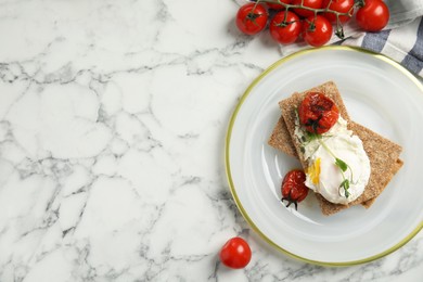 Photo of Fresh rye crispbreads with poached egg, cream cheese and grilled tomatoes on white marble table, flat lay. Space for text