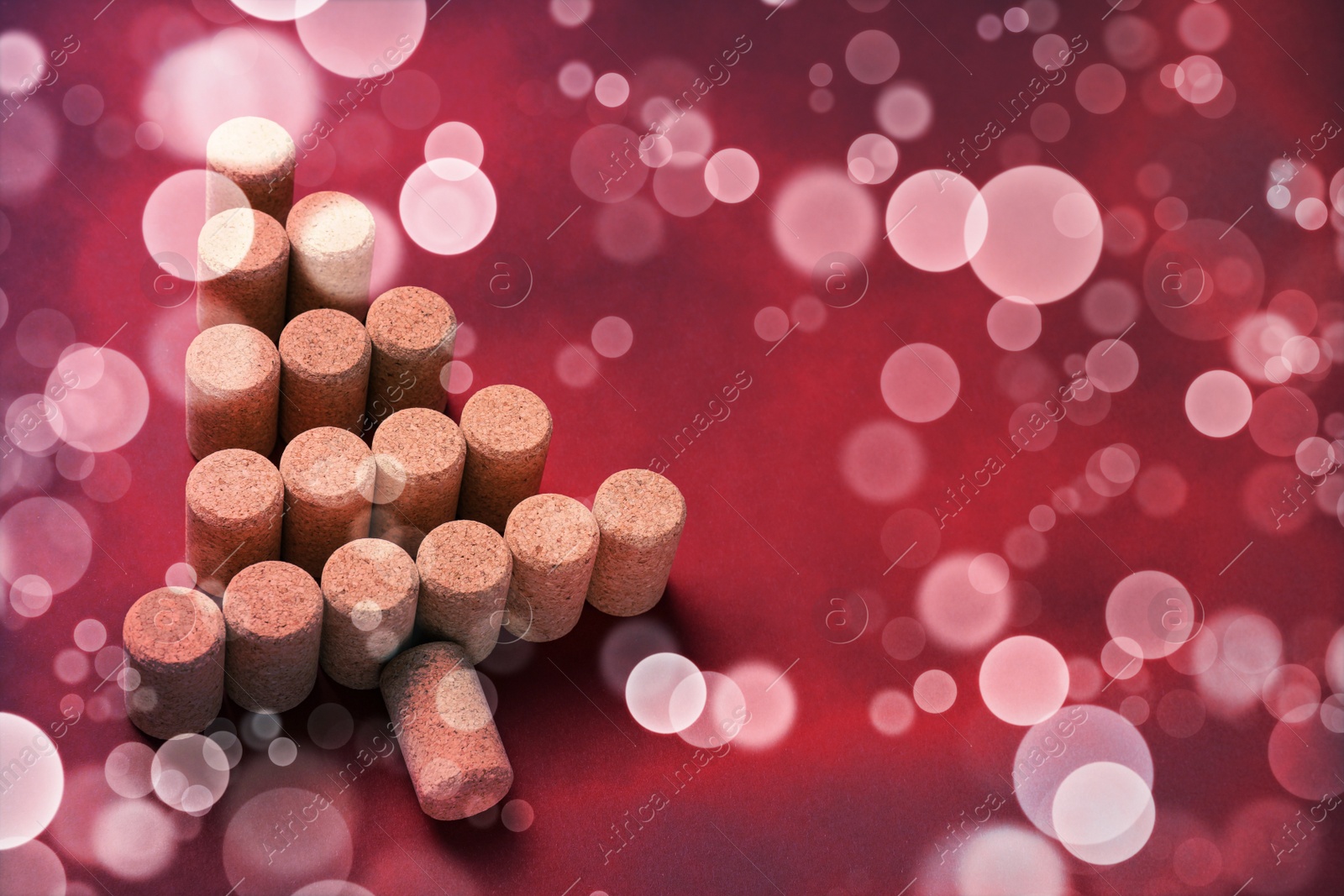 Image of Christmas tree made of wine corks on red background