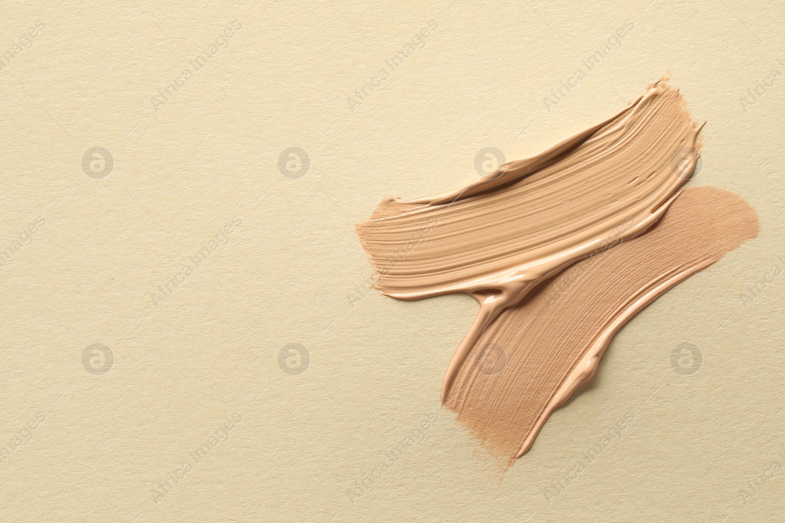 Photo of Samples of liquid skin foundations on beige background, top view. Space for text