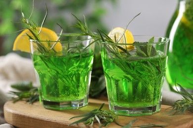 Refreshing tarragon drink with lemon slices on table, closeup