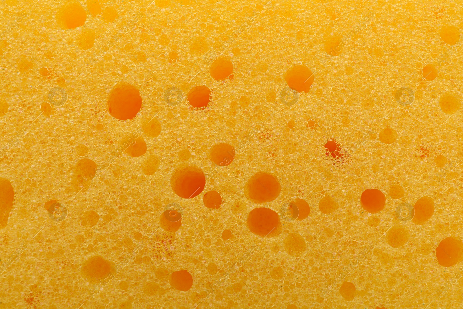 Photo of Yellow cleaning sponge as background, top view