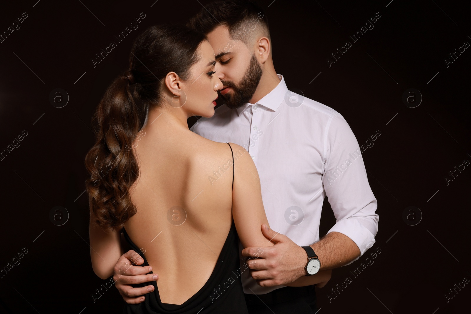 Photo of Handsome bearded man with sexy lady on dark background