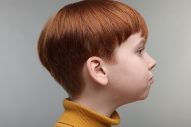 Hearing problem. Little boy on grey background