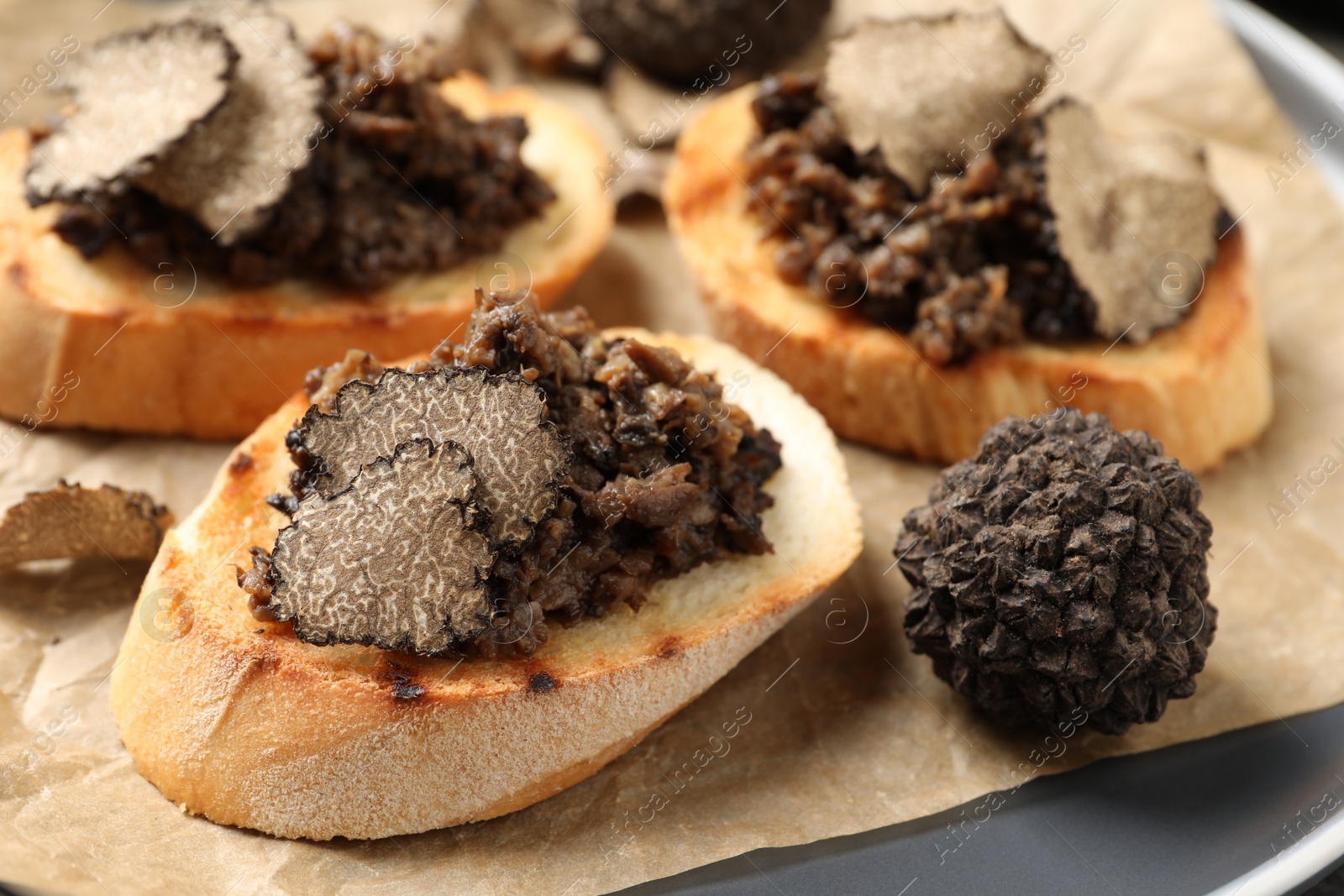 Photo of Delicious bruschettas with truffle sauce on plate, closeup