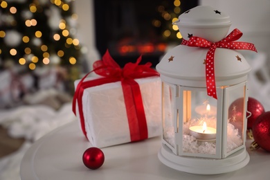 Photo of Beautiful Christmas lantern and other decorations on table in room