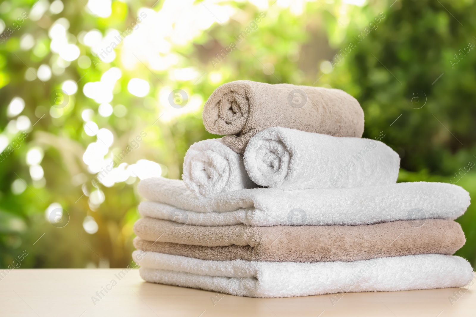 Photo of Soft bath towels on table against blurred background. Space for text