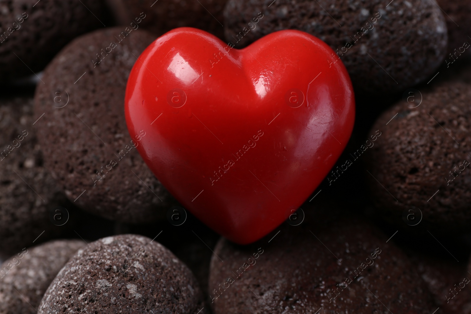 Photo of Red decorative heart on stones, closeup view