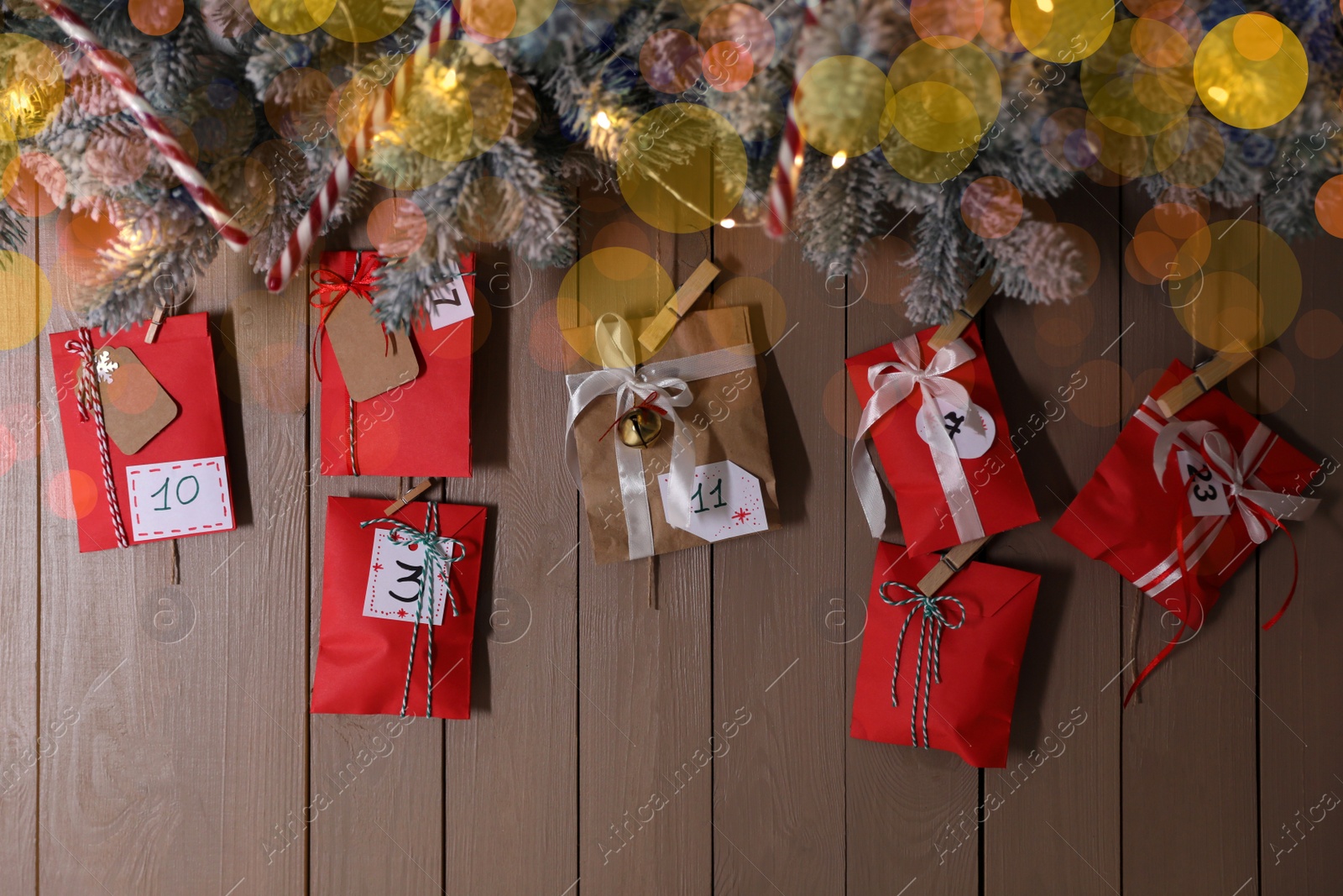 Photo of Christmas Advent calendar with gifts and decor hanging on wooden wall