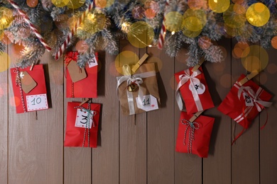 Photo of Christmas Advent calendar with gifts and decor hanging on wooden wall