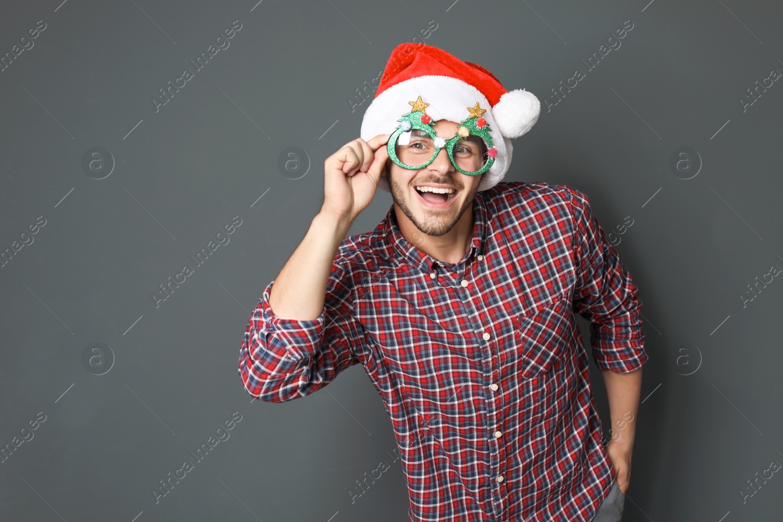 Photo of Young man in Christmas hat on grey background