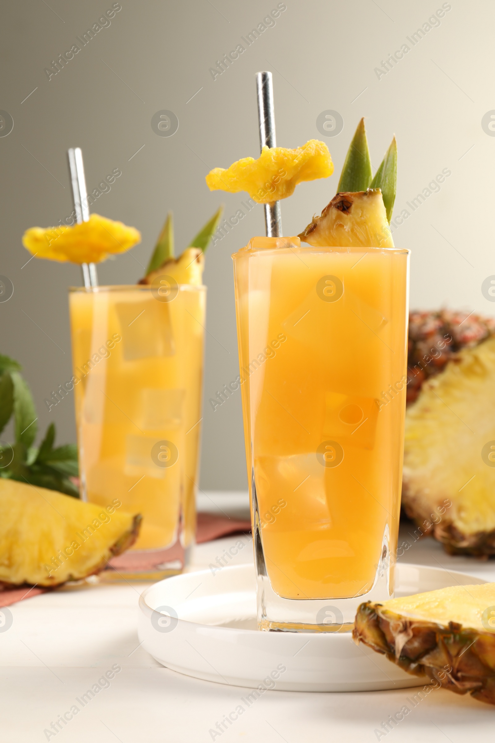 Photo of Tasty pineapple cocktail and sliced fruit on white table