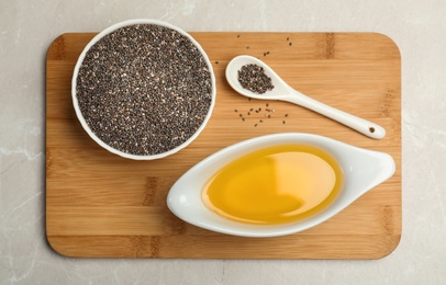 Photo of Composition with chia seeds and sauce boat of oil on grey table, top view