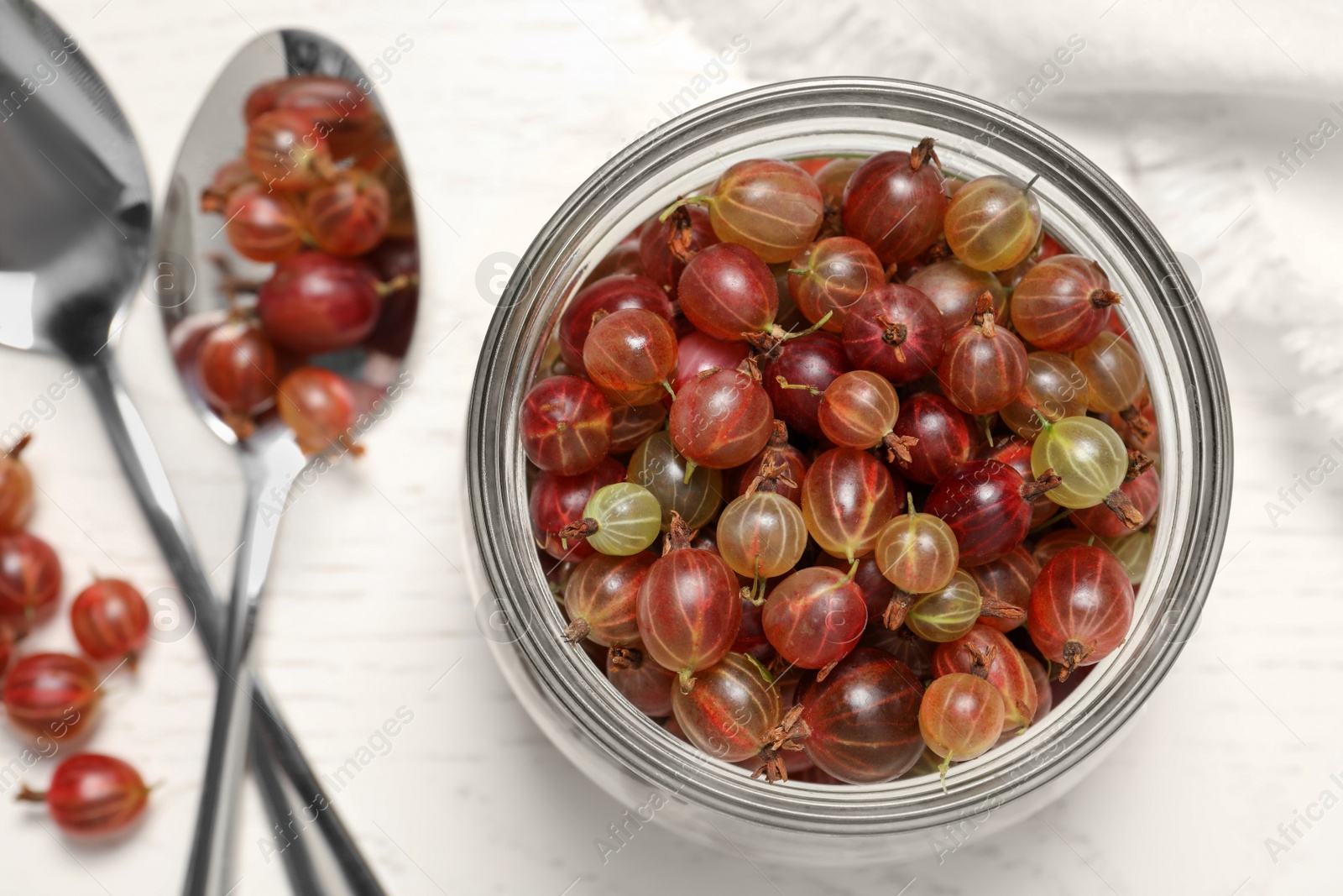 Photo of Many fresh ripe gooseberries on white wooden table, flat lay