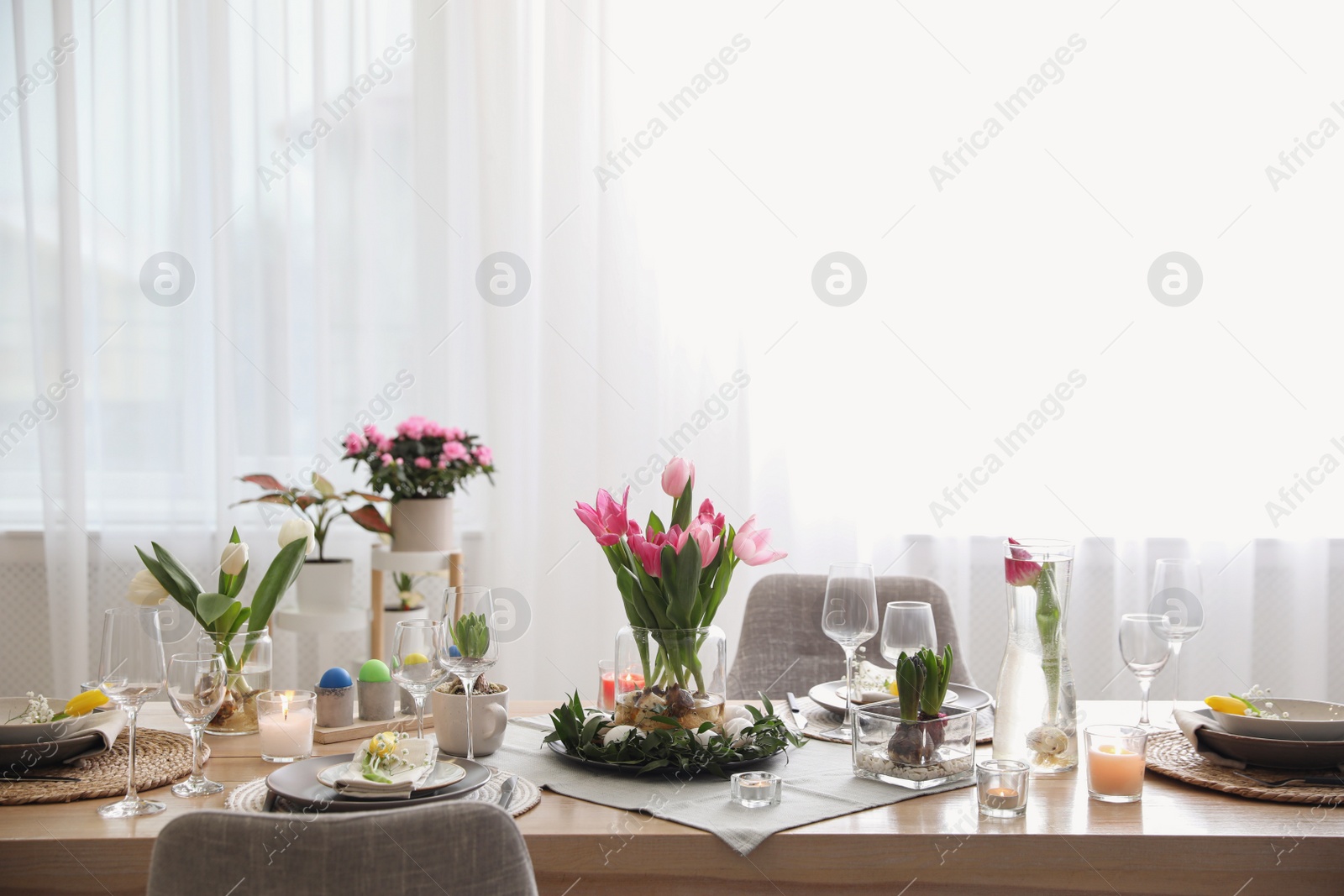 Photo of Beautiful Easter table setting with beautiful flowers in living room