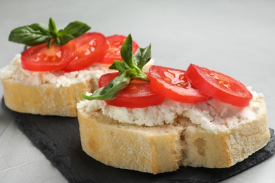 Photo of Tasty fresh tomato bruschettas on grey table, closeup