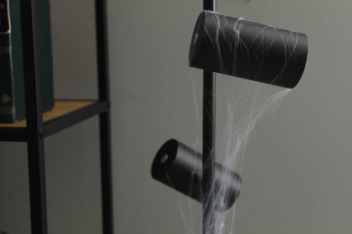Photo of Cobweb on lamp near rack indoors, closeup