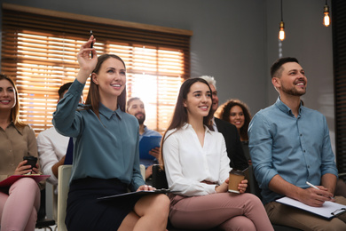Photo of Woman raising hand to ask question at seminar in office, closeup
