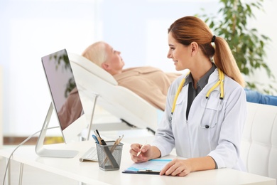 Photo of Professional doctor with mature patient in hospital