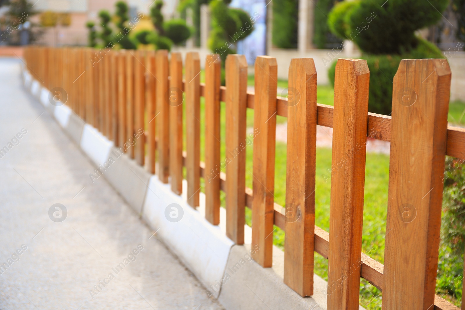 Photo of Small wooden fence on sunny day outdoors, closeup. Space for text