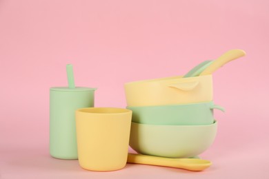 Photo of Set of plastic dishware on pink background. Serving baby food