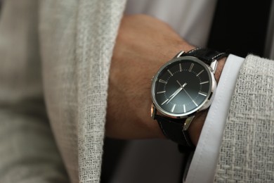 Photo of Businessman in jacket with luxury wrist watch, closeup