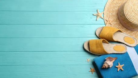 Beach accessories on light blue wooden background, flat lay. Space for text