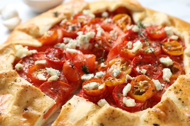 Photo of Tasty galette with tomato, thyme and cheese (Caprese galette) on table, closeup