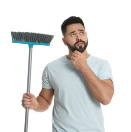Photo of Thoughtful young man with broom on white background