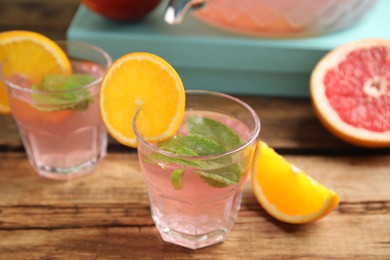 Photo of Delicious refreshing drink with orange and mint on wooden table