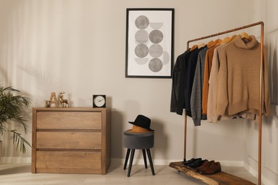 Photo of Modern dressing room interior with stylish clothes, shoes and decorative elements