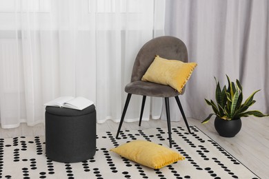 Photo of Stylish room interior with comfortable chair and beautiful window curtains